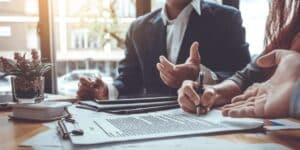 Home seller reviewing and signing a real estate purchase agreement with legal documents on desk | Can a Seller Back Out of a Real Estate Contract